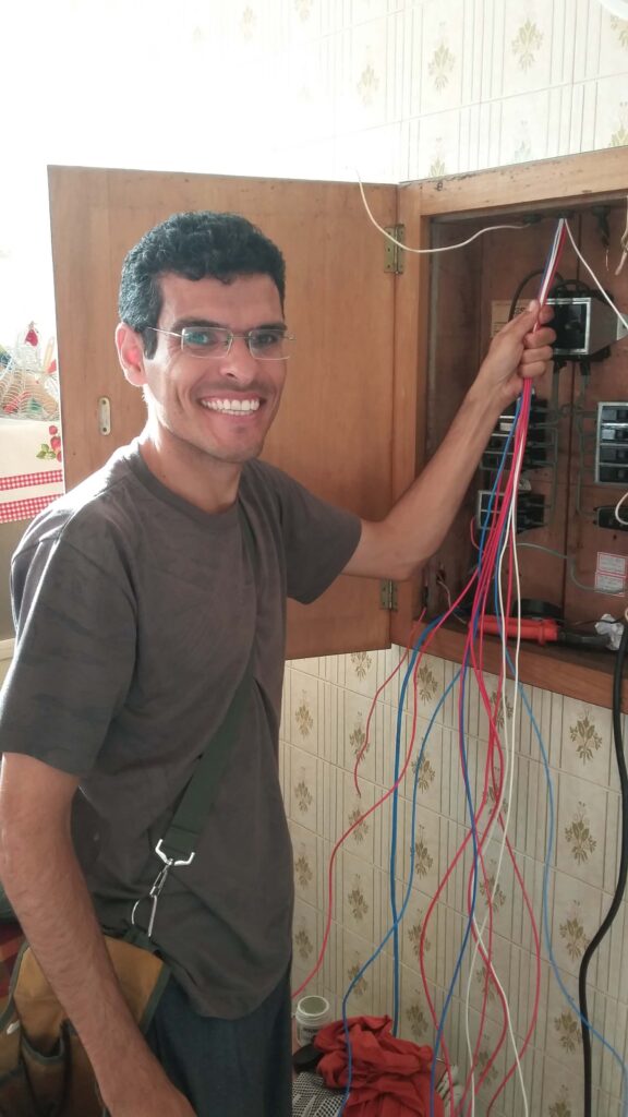 Eletricista passando cabos em um quadro